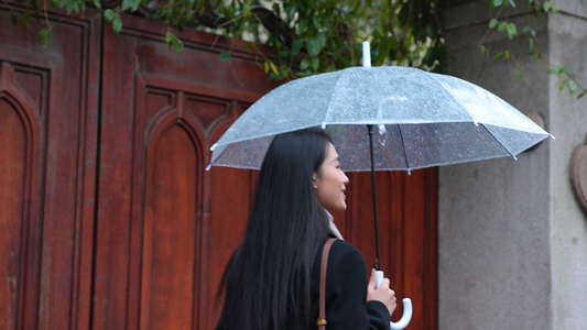  女人雨中撑伞漫步走着背影视频