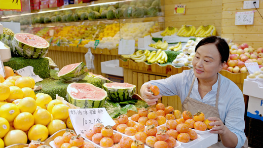 店员大妈检查摆放好的柿子是否完好视频