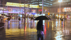 夜晚女人下班撑伞走向路边11秒视频