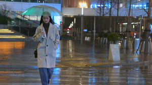 夜晚女人撑伞通过红绿灯路口20秒视频
