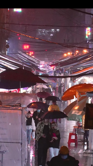 城市雨天夜晚打着伞夜市购物逛街的人群素材城市素材60秒视频