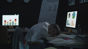 睡在暗办公室工作台前电脑上的疲劳商人11秒视频