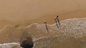 4k俯拍海边沙滩行人行走21秒视频