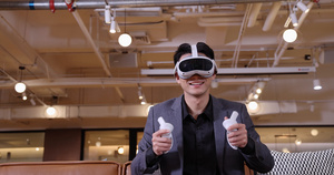 商务人士坐在沙发上玩VR游戏机16秒视频