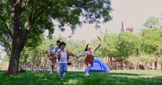 一家四口露营在草地上开心奔跑视频