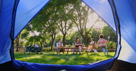 透过帐篷一家四口在露营地开心玩耍视频