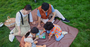 一家四口坐在野餐垫开心玩游戏15秒视频