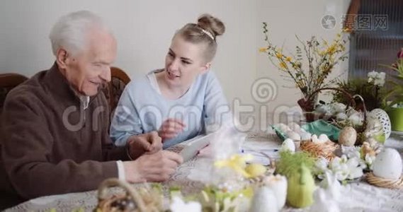 孙女和祖父使用数字平板电脑视频