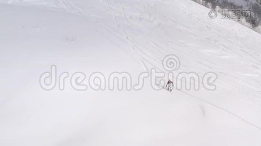 滑雪者骑着免费的滑雪板在粉末新鲜的雪坡上冬季森林景观。 空中观景滑雪者乘坐视频