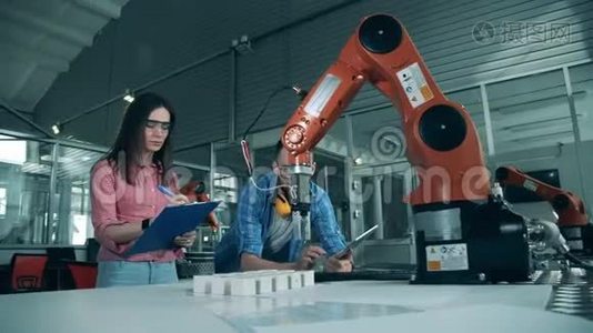 理工科学生正在监视一个机器人手臂重新定位物体视频