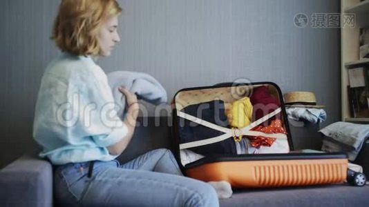 旅行妇女坐在沙发和行李箱边的侧视图准备上路视频