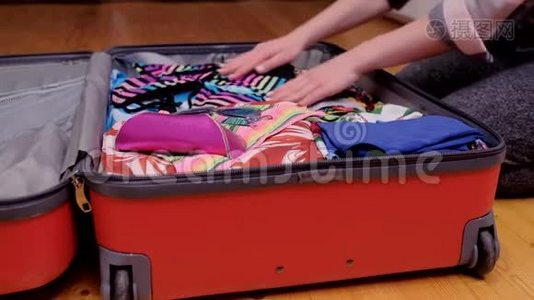 一个女人为旅行准备一个手提箱。视频