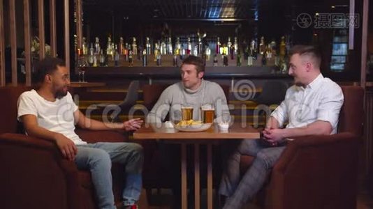 多元文化的朋友坐在酒吧，喝啤酒，聊天视频