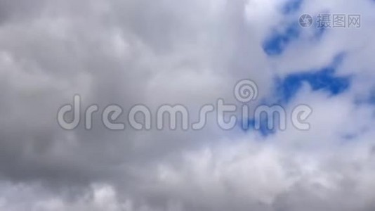 灰色和白色的黑雨云在天空中以一片蓝色移动视频