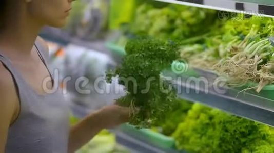 美国年轻女性在超市有机区购买绿叶蔬菜。视频