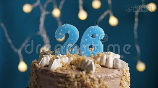 生日蛋糕，蓝色背景上有26支蜡烛。 蜡烛吹灭了。 慢动作和特写视频