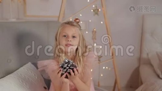 一个九岁的女孩在新年装饰手里拿着一个新年玩具。 2020年新年。视频