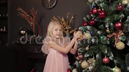 一个十岁的女孩靠近新年树，手里拿着一个新年玩具。 2020年新年。视频