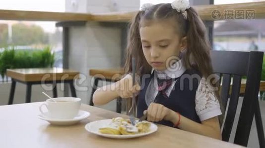 穿校服的小女孩在学校食堂吃午饭。视频