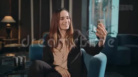 在酒店休息室在线使用智能手机视频通话的快乐女人视频