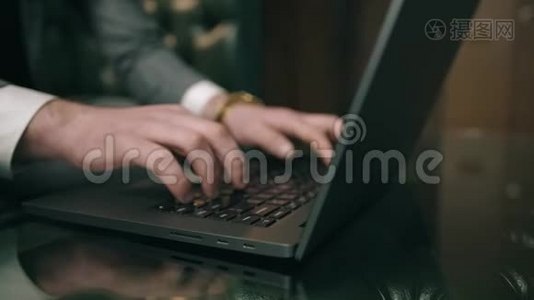 穿西装的商人坐在室内使用笔记本电脑视频