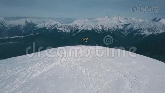 空中飞弹飞过胜利者雄雪板运动员欣赏岩石峰上的山景视频