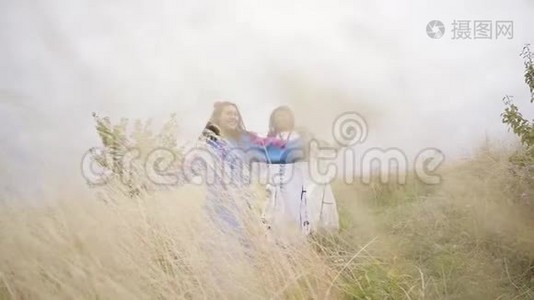 三个女朋友穿着漂亮的夏装，刺绣在田野里跳跃，穿过田野视频