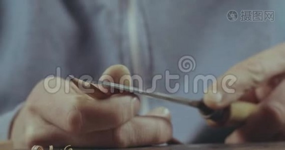 男性手的特写-用凿子磨铅笔。 磨一个简单的铅笔。 电影4K录像视频