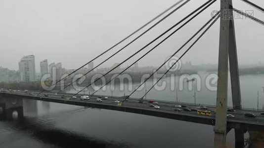 巨大的混凝土灰色桥梁与钢缆结合在大都市的两侧工业烟雾。 汽车和公共交通工具视频