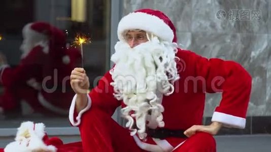 圣诞老人坐在城市办公楼附近，手里拿着星星之火视频