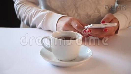 歪歪扭扭的形象，年轻妇女坐在一张桌子上，喝咖啡或茶，用手机。视频