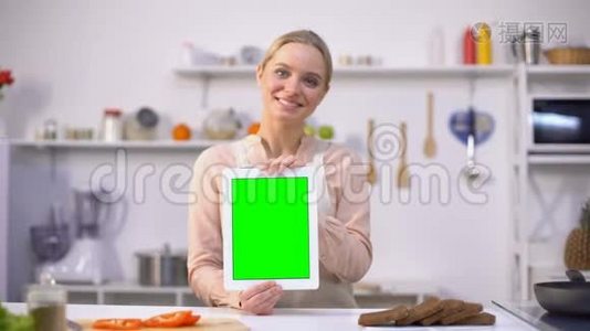 美丽的女孩手持平板电脑，绿色屏幕，易于烹饪移动应用视频