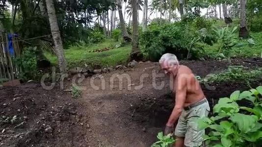 老人在他的花园里挖了个洞。视频