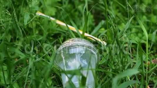 女人`手把塑料杯从草地上移开，把塑料杯移开视频