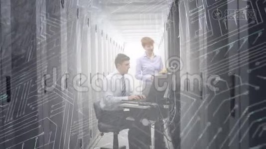 一个男人和一个女人在电脑服务器室工作，而发光的电路板在前台移动视频