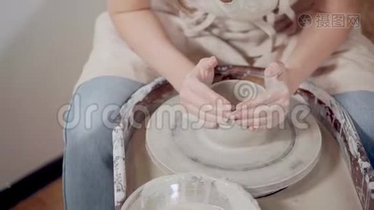 女陶工正在用陶工`的轮子、特写来制作陶土碗视频