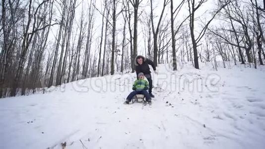 活跃的孩子骑在雪橇上，从雪山森林，家庭假日视频