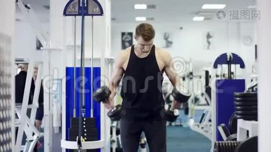 年轻健美运动员在健身房用哑铃锻炼视频