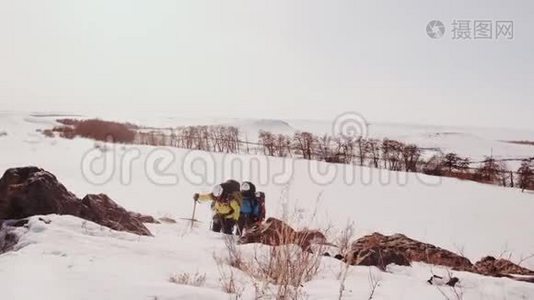 一群勇敢的登山者克服严冬天气和大雪爬上一座又大又陡的山视频