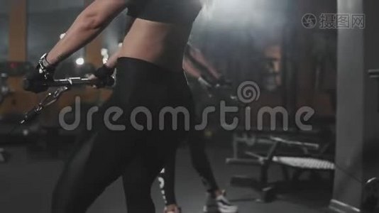 金发蹲在黑暗健身房的模拟器里。 健身女蹲加强腿部视频