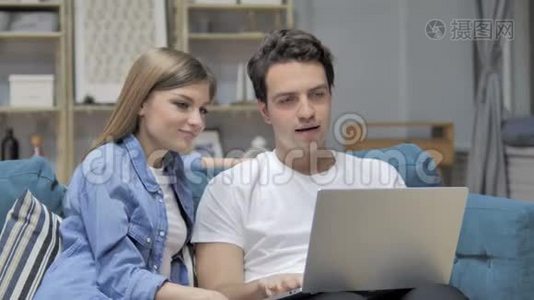 年轻夫妇在家里在笔记本电脑上在线视频聊天视频