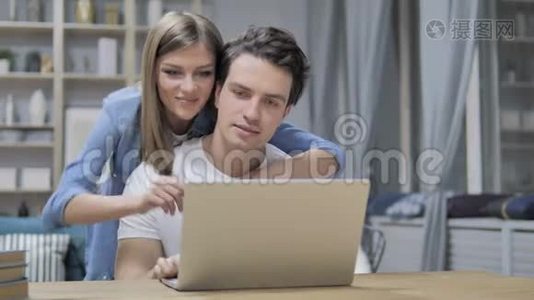 快乐的年轻夫妇用笔记本电脑在网上选购东西视频