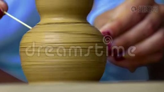 特写女孩用棍子在粘土花瓶上做浮雕图案视频