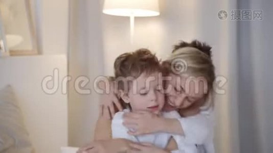 幸福的家庭-母亲和两个儿子拥抱在床上视频