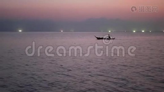 日落时分，在海上渔船灯光之间的人。 浅顶剪影航运图片视频