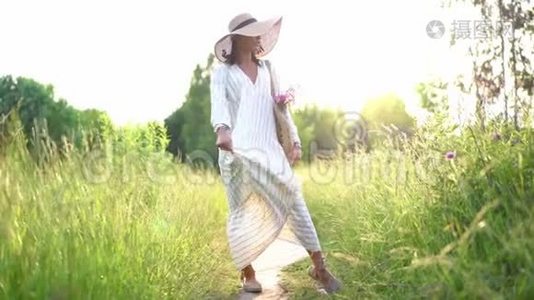 戴着牙套的女人在田野上的夕阳上微笑，穿着浪漫的连衣裙。 会飞的头发。 室外视频