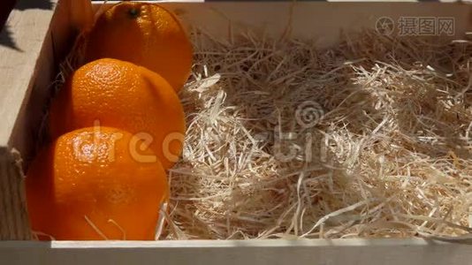 手把成熟多汁的橘子放进木箱里视频