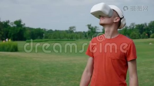 一个男人在公园里用VR耳机环顾四周视频