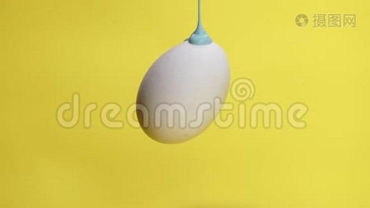 蓝色的油漆在空气中的鸡蛋淋淋上流动视频