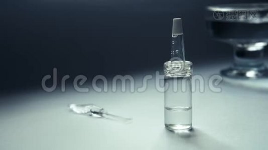 一个装有乳清的吸管的玻璃瓶在桌子上，玻璃容器的背景是水的摇摆。视频